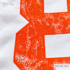 Close-up of distressed orange number printing and cotton knit texture on a white garment. The Big Man Designs.