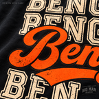 Macro detail of orange Bengals script, cream varsity lettering and black outlines printed on black cotton fabric.