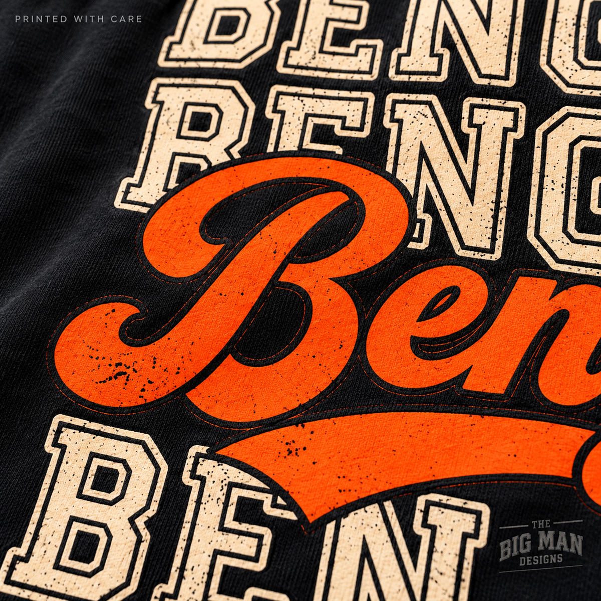 Macro detail of orange Bengals script, cream varsity lettering and black outlines printed on black cotton fabric.