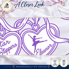 Close-up of original purple heart charm, ballerina, Eleanor lettering and white ribbon details