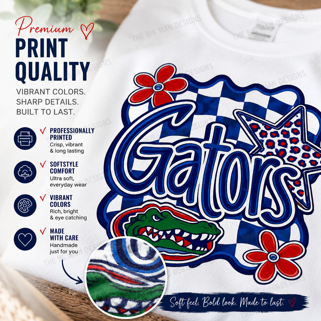 A white crewneck sweatshirt featuring a large Gators graphic print with blue, red, and white colors. The graphic includes the word 'Gators' in bold blue letters, a red alligator head, a red flower, and a blue-and-white checkered border.
