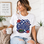 A woman sitting on a couch wearing a white graphic t-shirt with a blue and red Gators design, holding a white mug in a cozy living room setting.
