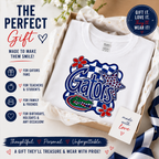 A white t-shirt in a gift box with tissue paper, featuring a large 'Gators' graphic in blue, red, and navy on the front. The image is a promotional gift graphic with text overlays, icons, and a 'made with love' card.