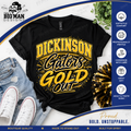 A black graphic T-shirt laid flat with distressed blue jeans, white sneakers, and a gold-and-black pom-pom accessory around it. The shirt has a large yellow and black 'DICKINSON Gators GOLD OUT' design.