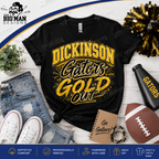 A black graphic T-shirt laid flat on a white wood background with styled props including jeans, white sneakers, a football, a pom-pom, a notebook, and a black megaphone. The shirt reads 'DICKINSON Gators GOLD OUT' in large yellow and black lettering.
