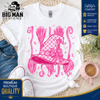 A white graphic t-shirt featuring a pink witch hat design with a checkered pattern, bow, and broomsticks. The t-shirt is styled in a flat-lay arrangement with blue jeans, white sneakers, a pink mug, and a wicker mat, with promotional badges from 'The Big Man Designs' visible.
