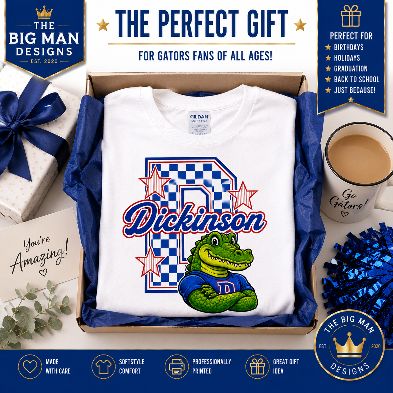 A Gildan white custom graphic t-shirt presented inside a brown cardboard gift box with blue satin lining, surrounded by gift packaging, a coffee mug, blue pom-poms, and decorative text banners. The shirt features a large blue and white checkered letter 'R' with stars, the name 'Dickinson' in blue script, and a green alligator mascot wearing a blue 'R' jersey.