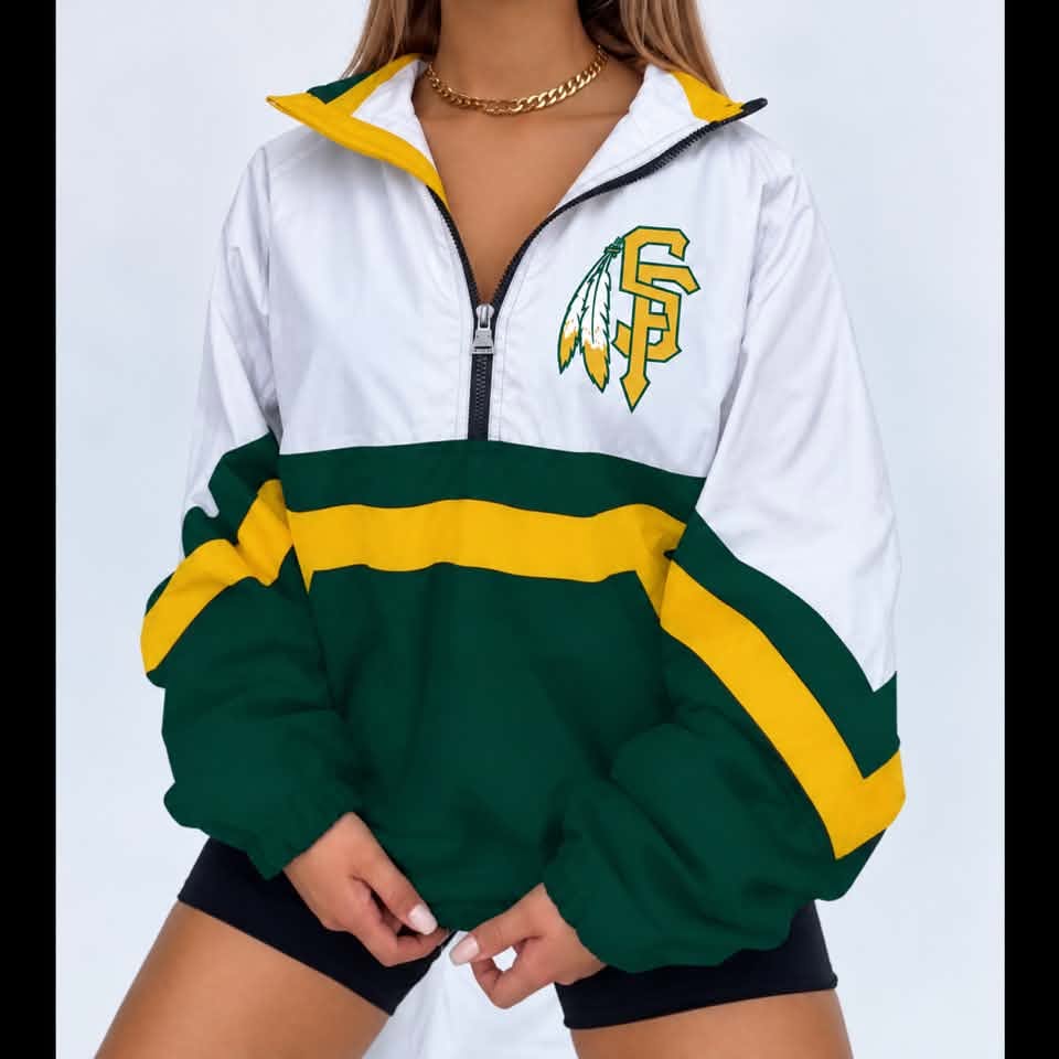 A woman wearing a white, green, and yellow half-zip windbreaker jacket with a green and yellow feathered 'SF' logo on the chest, paired with black shorts.