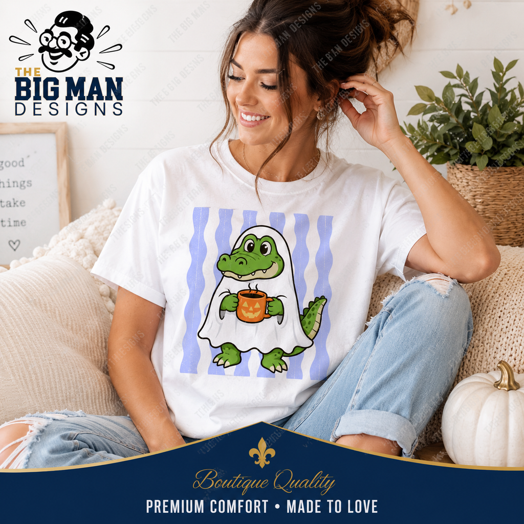 A woman sitting on a couch wearing a white graphic T-shirt with a cartoon alligator in a ghost holding a pumpkin, paired with light blue jeans. The image includes 'The Big Man Designs' branding and a decorative banner at the bottom.
