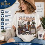 A woman wearing a cream graphic t-shirt with a Halloween-themed skeleton teacher design, sitting in a cozy room setting and holding a mug. The image includes promotional text overlays and badges for 'The Big Man Designs'.