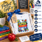 A folded white T-shirt presented in a wooden gift box with a blue ribbon and a handwritten tag reading 'Teachers Change Lives.' The shirt has a colorful 'Sped Story' classroom-themed graphic on the front.