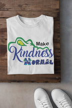 Flat-lay of the kindness-themed t-shirt paired with jeans and sneakers for a trendy school spirit look.