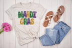 Mardi Gras Faux Glitter Teacher T-Shirt | DTF Printed 
Get ready to let the good times roll with this festive Mardi Gras teacher t-shirt! 🎉 Featuring a faux glitter design (no mess, just sparkle!) on a super soft Gildan Softstyle tee, this is the perfect shirt for parades, classroom celebrations, or everyday fun. Natural color gildan shirt