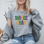 Mardi Gras Faux Glitter Teacher T-Shirt | DTF Printed 
Get ready to let the good times roll with this festive Mardi Gras teacher t-shirt! 🎉 Featuring a faux glitter design (no mess, just sparkle!) on a super soft Gildan Softstyle tee, this is the perfect shirt for parades, classroom celebrations, or everyday fun. Grey Gildan tshirt