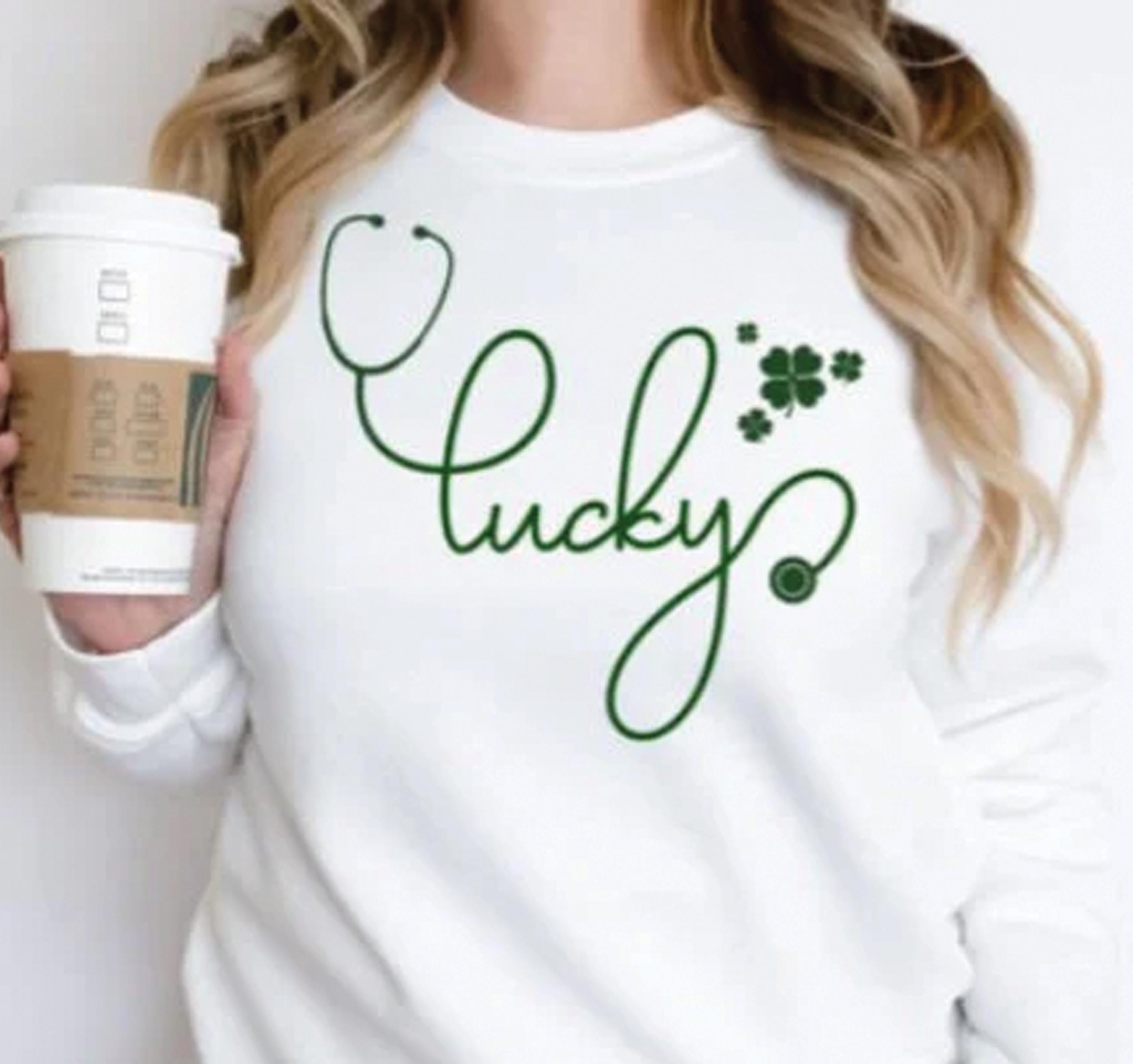 A Lucky Stethoscope Shirt designed for nurses, doctors, and medical professionals. This St. Patrick’s Day tee features the word "Lucky" creatively formed with a stethoscope in a high-quality DTF print. Made from 100% cotton, available in sport grey, natural, black, and white. A perfect medical-themed lucky shirt for nurse life, hospital workers, or a St. Paddy’s celebration. Soft, stylish, and durable—no cracking or peeling!