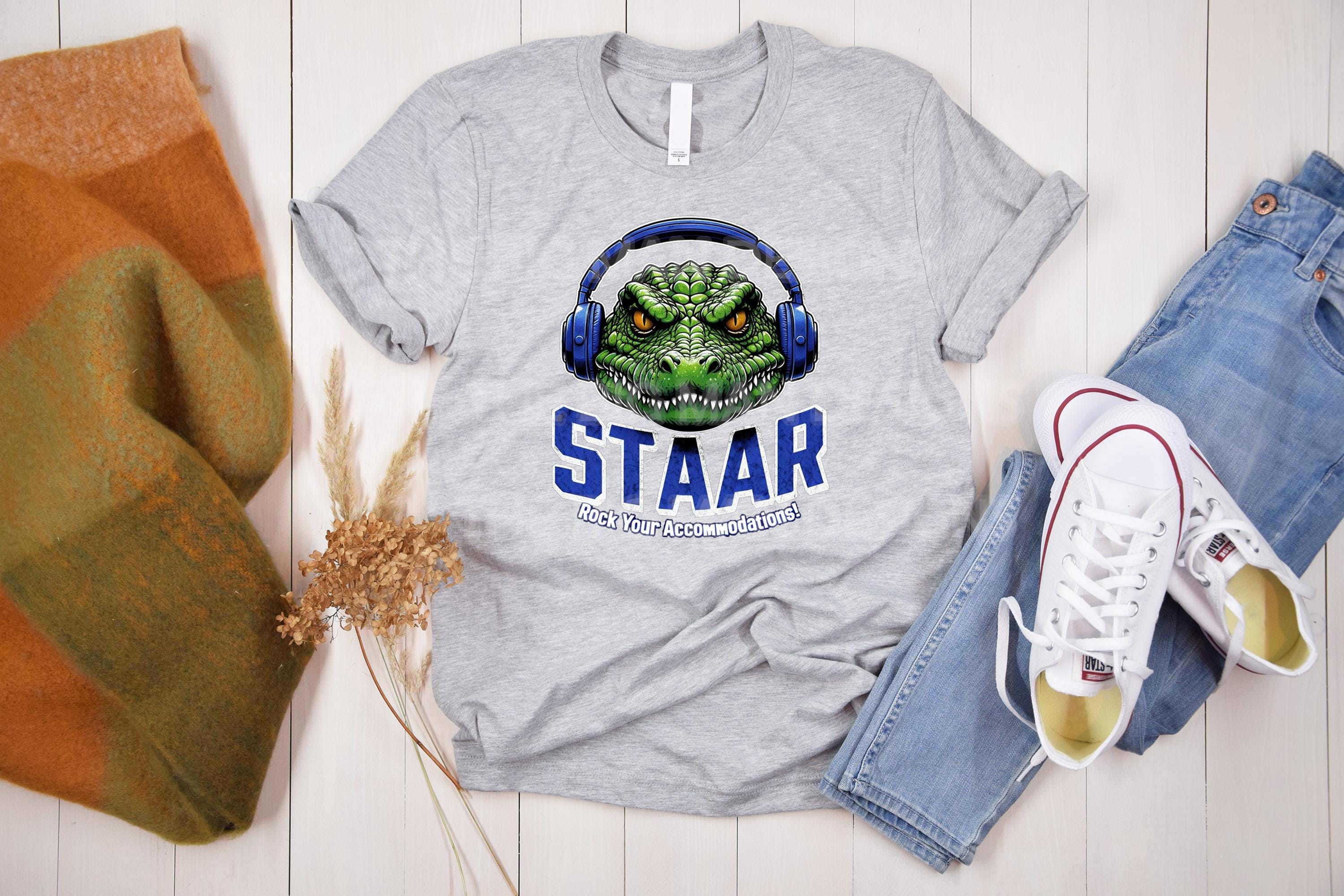 Get ready to rock testing season with this high-quality DTF transfer featuring a gator head wearing headphones and the phrase STAAR Rock Your Accommodations! Perfect for teachers, administrators, and school staff, this ready-to-press transfer makes it easy to create custom shirts for testing season! On grey