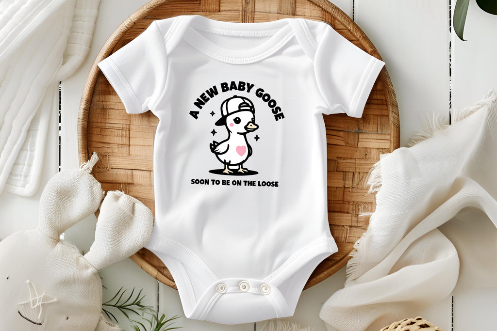A New Baby Goose Soon to Be on the Loose! 🎉 Celebrate your exciting news with this adorable and funny baby announcement onesie. Perfect for pregnancy announcements, baby showers, gender reveals, or a sweet newborn gift. This charming bodysuit features a cute little goose wearing a stylish cap, adding a fun twist to your special moment!