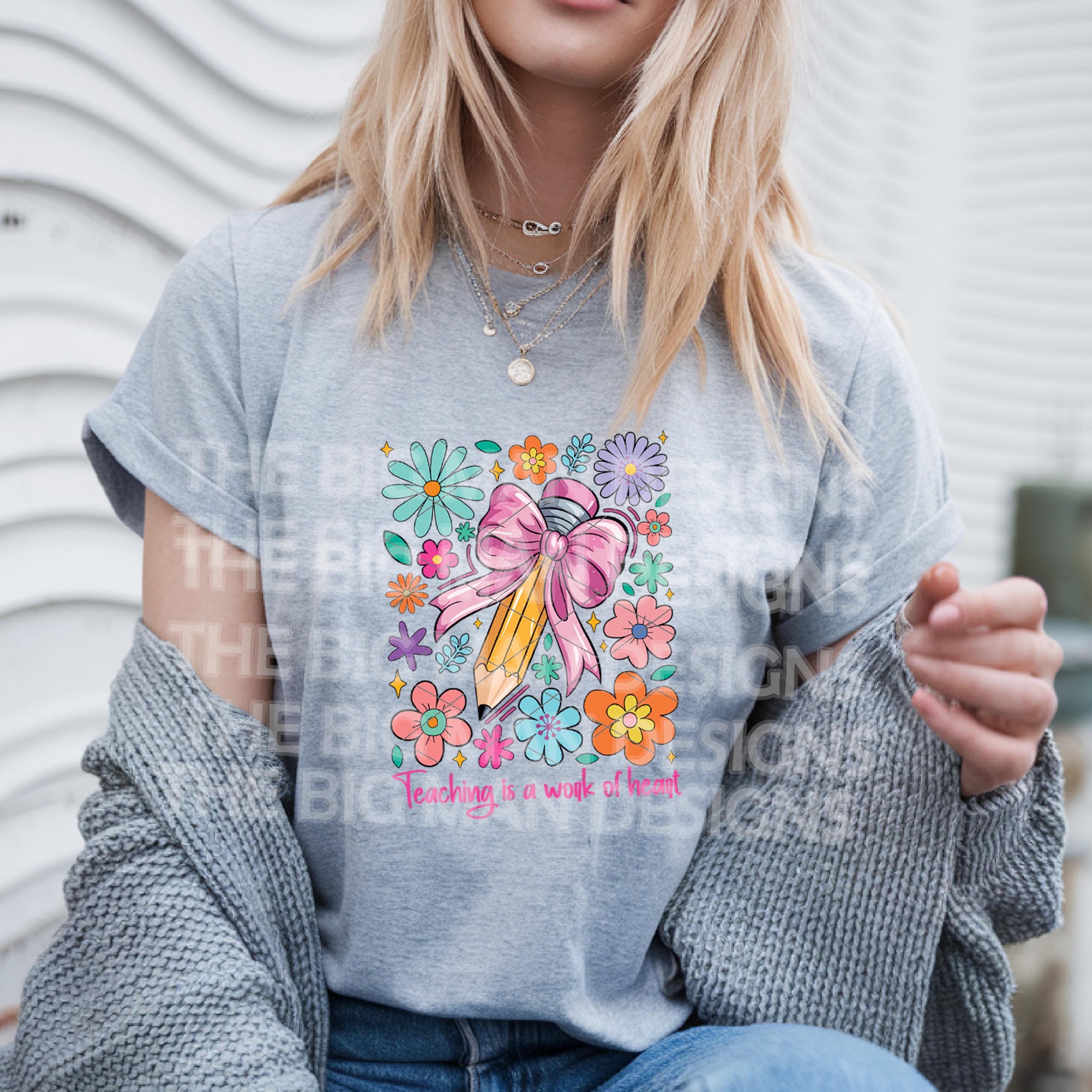 Woman in a sport grey t-shirt featuring "Teaching is a Work of Heart" pencil and flower print.