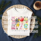 Folded white t-shirt displayed in a wicker tray with festive "Teach Love Inspire" print.