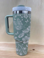 Laser engraved cherry blossom tumbler with white lid and handle, sage green color