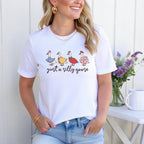Smiling woman wearing white shirt with funny goose DTF transfer outside with flowers