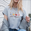 Blonde woman wearing heather grey goose shirt with cardigan and layered necklaces