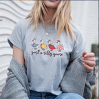 Blonde woman wearing heather grey goose shirt with cardigan and layered necklaces