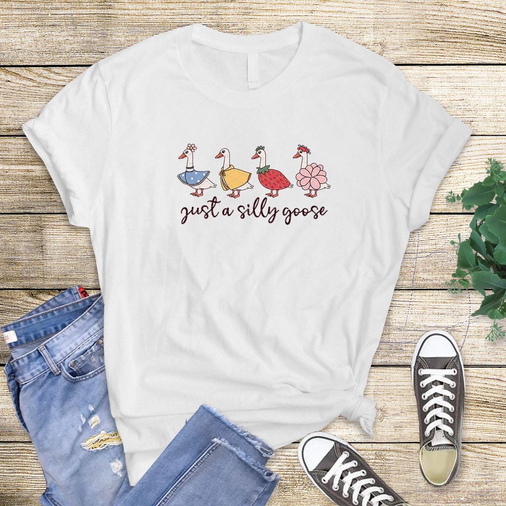 White flat lay T-shirt with "Just a Silly Goose" multi-goose lineup design.