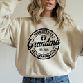 Grey t-shirt with black "Promoted to Grandma" print worn by woman outdoors.