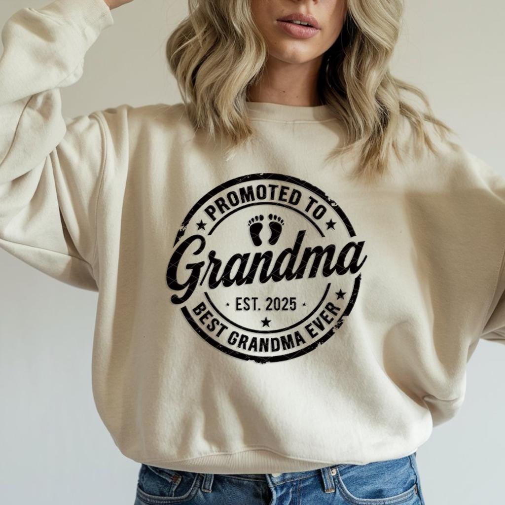 Grey t-shirt with black "Promoted to Grandma" print worn by woman outdoors.