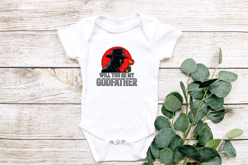 Flat lay with white wood background and eucalyptus leaves showcasing mafia-themed baby onesie.