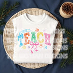 White folded T-shirt displayed on cozy background with colorful "TEACH" sketch.