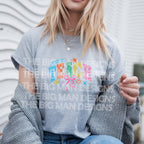 Woman in grey T-shirt with "TEACH" colorful graphic and casual outfit.