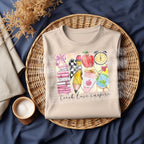 Folded natural color sweatshirt with colorful school-themed "Teach Love Inspire" design