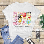 Flat lay of white t-shirt with colorful "Teach Love Inspire" design, styled with jeans and sneakers.