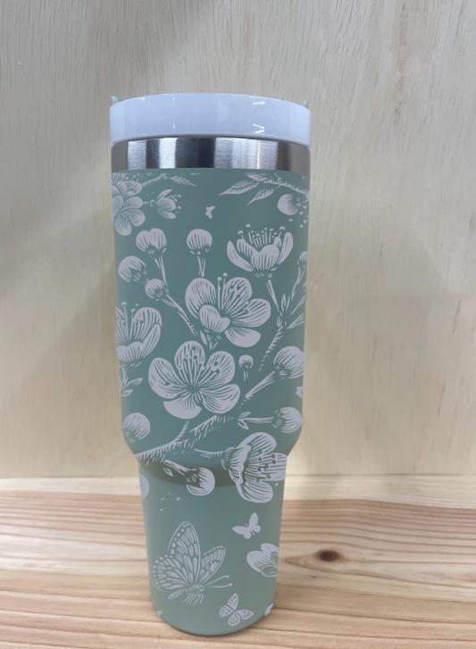 Close-up of laser engraved cherry blossoms and butterflies on pastel tumbler