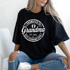 Black t-shirt with white "Promoted to Grandma" print worn casually with jeans.