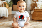 Baby sitting up smiling wearing mafia godfather proposal onesie.