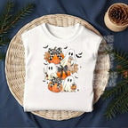 Flat lay mockup of white shirt with pumpkin ghost and bow DTF transfer applied