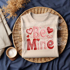 Faux yarn BE MINE Valentine DTF transfer on cream shirt flat lay mockup