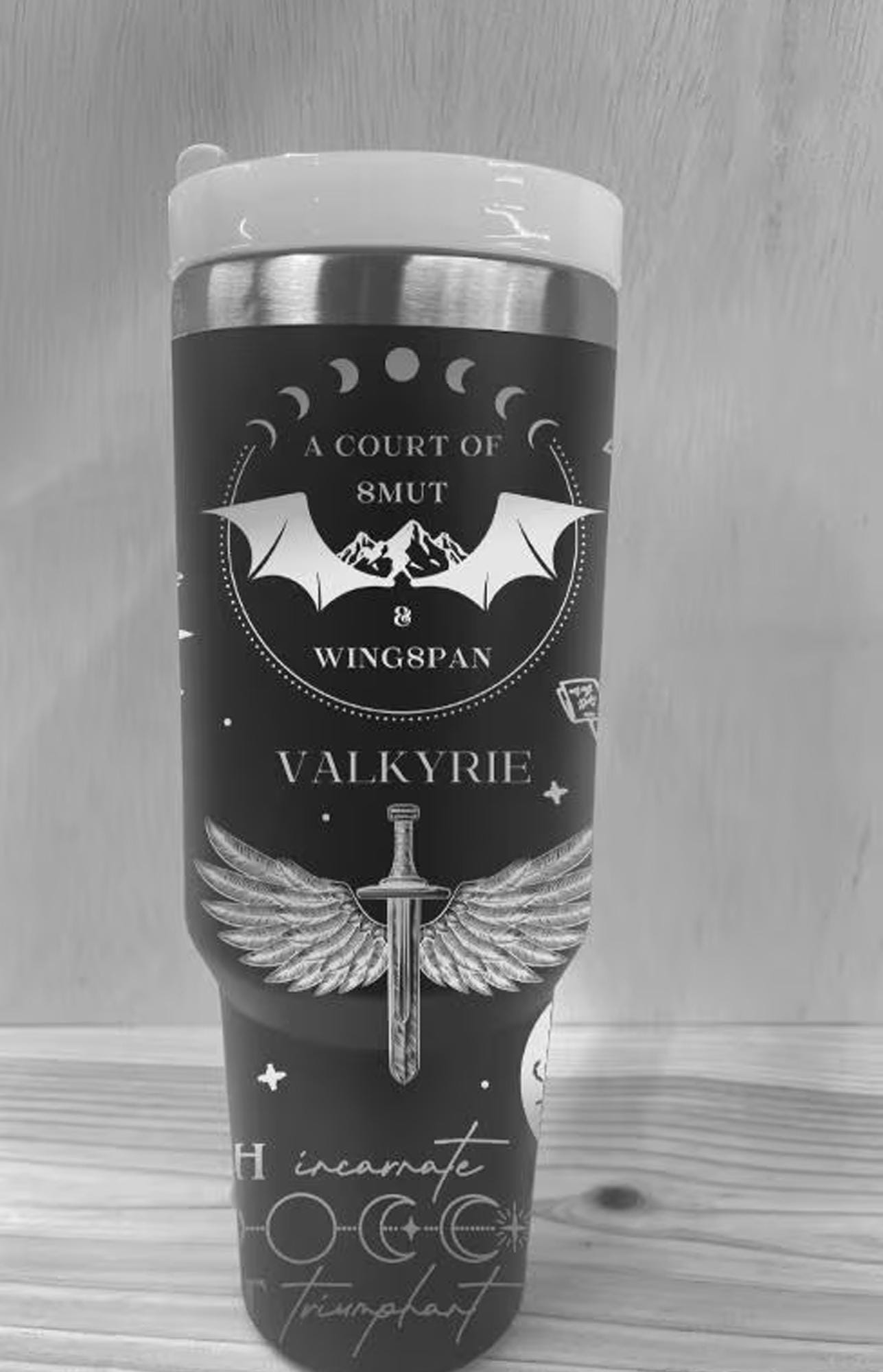 May include: A black stainless steel tumbler with a graphic design featuring a bat, wings, a sword, and the text "A Court of 8mut & Wing8pan Valkyrie"