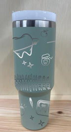 May include: A sage green stainless steel travel mug with a sage green handle and a clear lid. The mug has a silver design engraved into it.