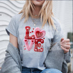 Woman wearing gray Valentine t-shirt with fuzzy chenille LOVE heart patch style design outdoors