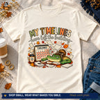 Natural fall timeline gator T-shirt styled with jeans, coffee, and autumn accents.